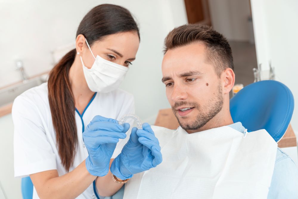 Orthodontist showing Invisalign clear aligners to patient